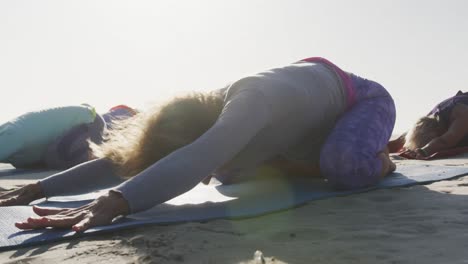 mujeres atléticas realizando yoga en la playa