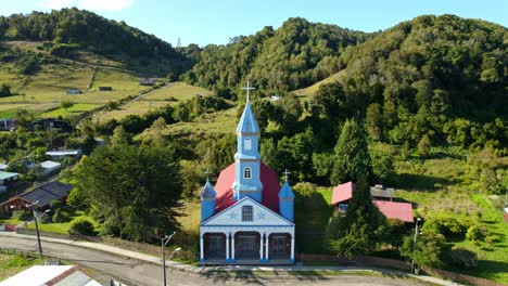 vista aérea inclinada hacia la iglesia de tenaún en el soleado chiloé, chile