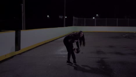 girl dribbles ball at outdoor court, turns and shoots basketball in net under lights with a swish