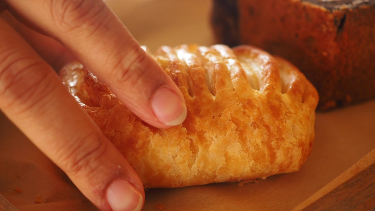 Hand Picking Up a Golden Brown Puff Pastry