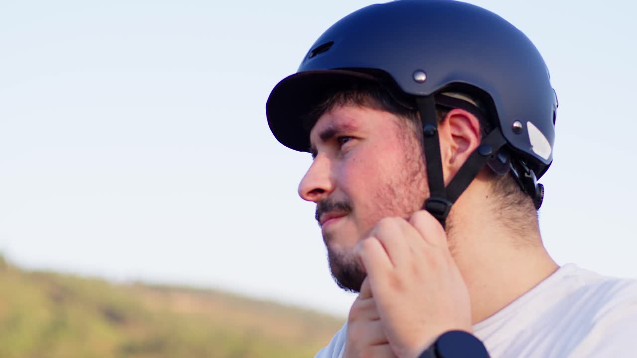 4k cámara lenta de un ciclista poniéndose el casco, haciendo hincapié en la seguridad y el enfoque antes de comenzar el viaje.
