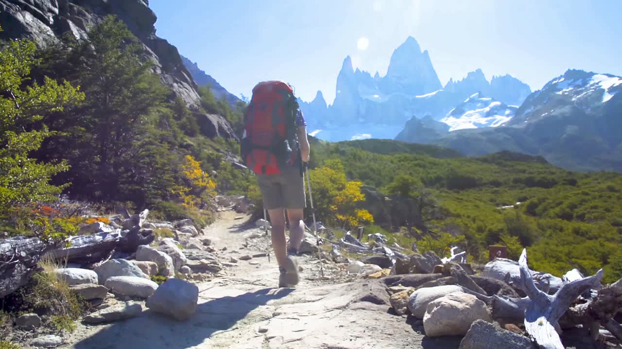 mujer joven con mochila caminando por un sendero en la patagonia, argentina