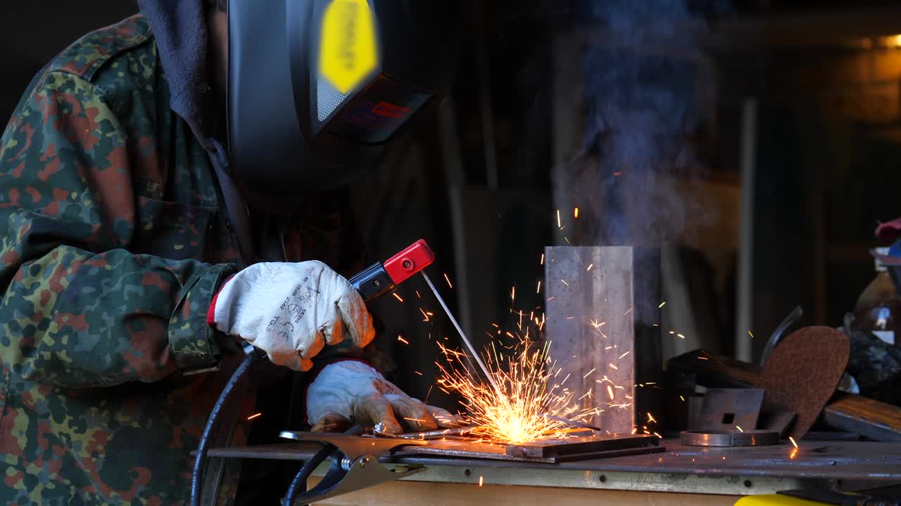 woman welding with electric welding machine