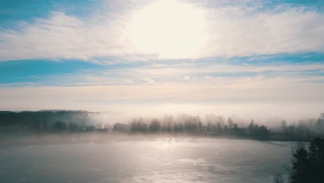 aerial view of foggy spring landscape and small village in sunny morning