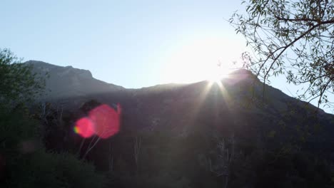 bright sun shining over the mountain peak in summer