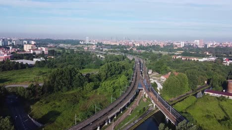 city skyline of milan and passenger train leaving, aerial view