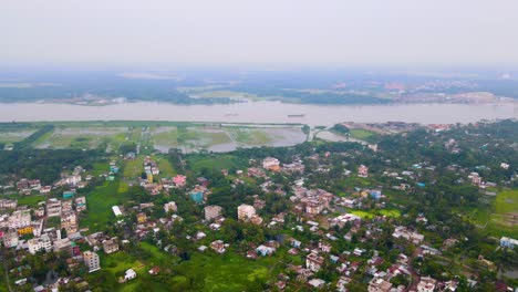 aerial forward city barisal, bangladesh and river kirtankhola, cloudy day