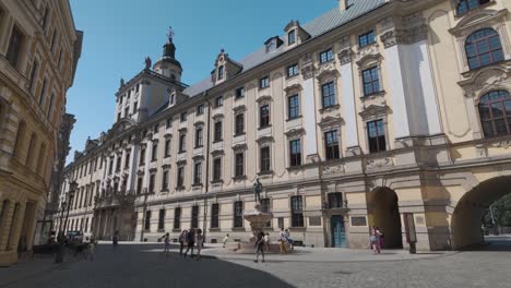 university square in wroclaw, poland, showcasing historic architecture and vibrant atmosphere on a sunny day. visitors enjoy the scenic buildings and open space.