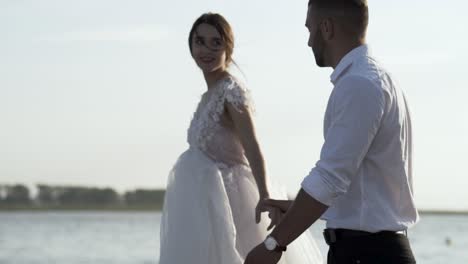 couple walking by the lake on their wedding day