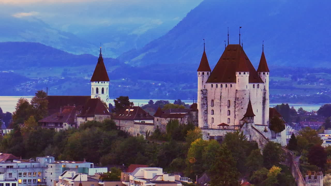 Aerial cinematic drone downtown Thun Switzerland cars Swiss village city downtown stunning Thun Castle Dukes of Z&auml;hrigen Interlocken Bern Jungfrau cloudy sunrise sunset circle right parallax movement