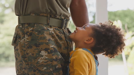 close up of loving army father in uniform home on leave hugging daughter