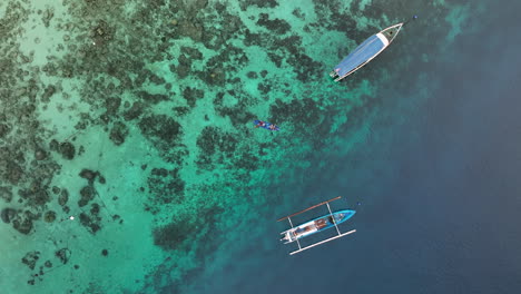 Two-people-kayaking-off-the-coast-of-Gili-Trawangan-at-sunrise,-Indonesia