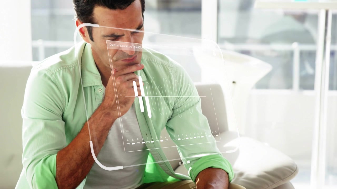 Uomo che digita e studia una forma d'onda con un HUD che appare sopra il laptop per una recensione tecnologica.