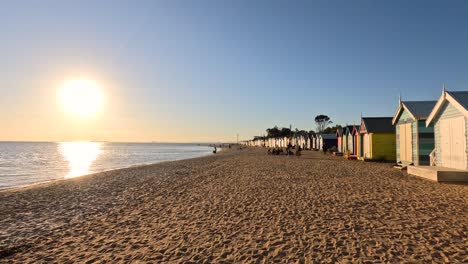 colorful beach huts with a setting sun