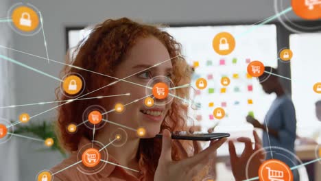 animación de una red de iconos digitales contra una mujer caucásica hablando con un teléfono inteligente en la oficina