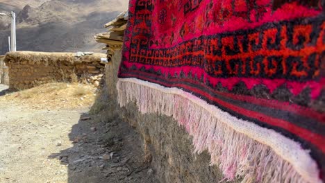 local people wash red handmade wool silk carpet the persian art of weaving rug in iran nomad rural life village town countryside stone house mountain landscape wonderful peaceful life in remote