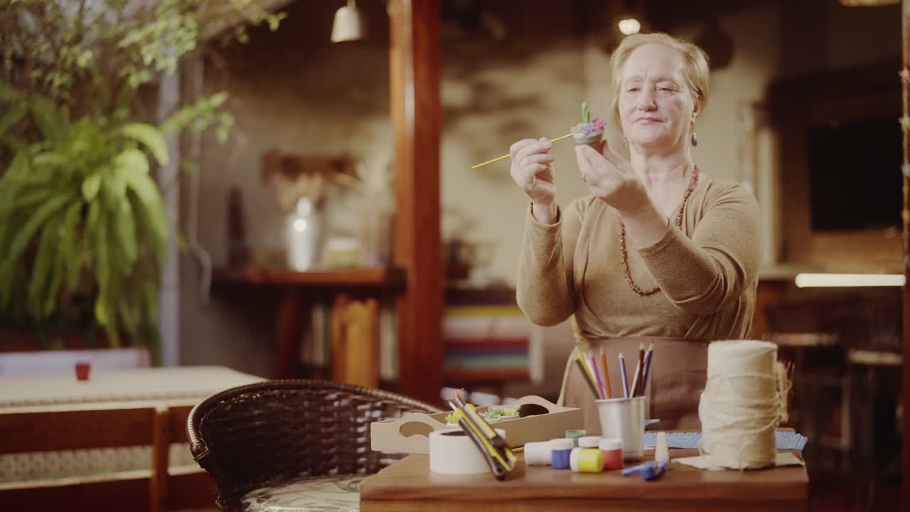 Senior woman painting a craft project at home
