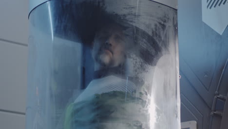 man in a futuristic cryo-sleep chamber