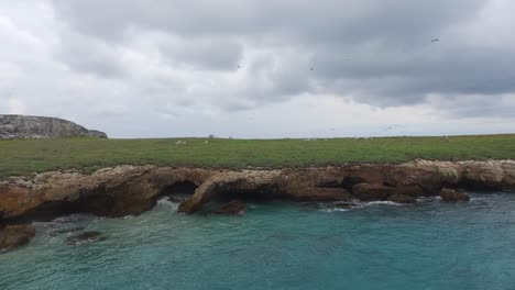 toma aérea de un barco, pájaros y formaciones rocosas en la isla larga, islas marietas, nayarit, méxico