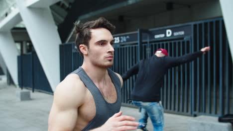 Handsome-man-running-on-urban-street.-Portrait-muscular-man-jogging-outdoor