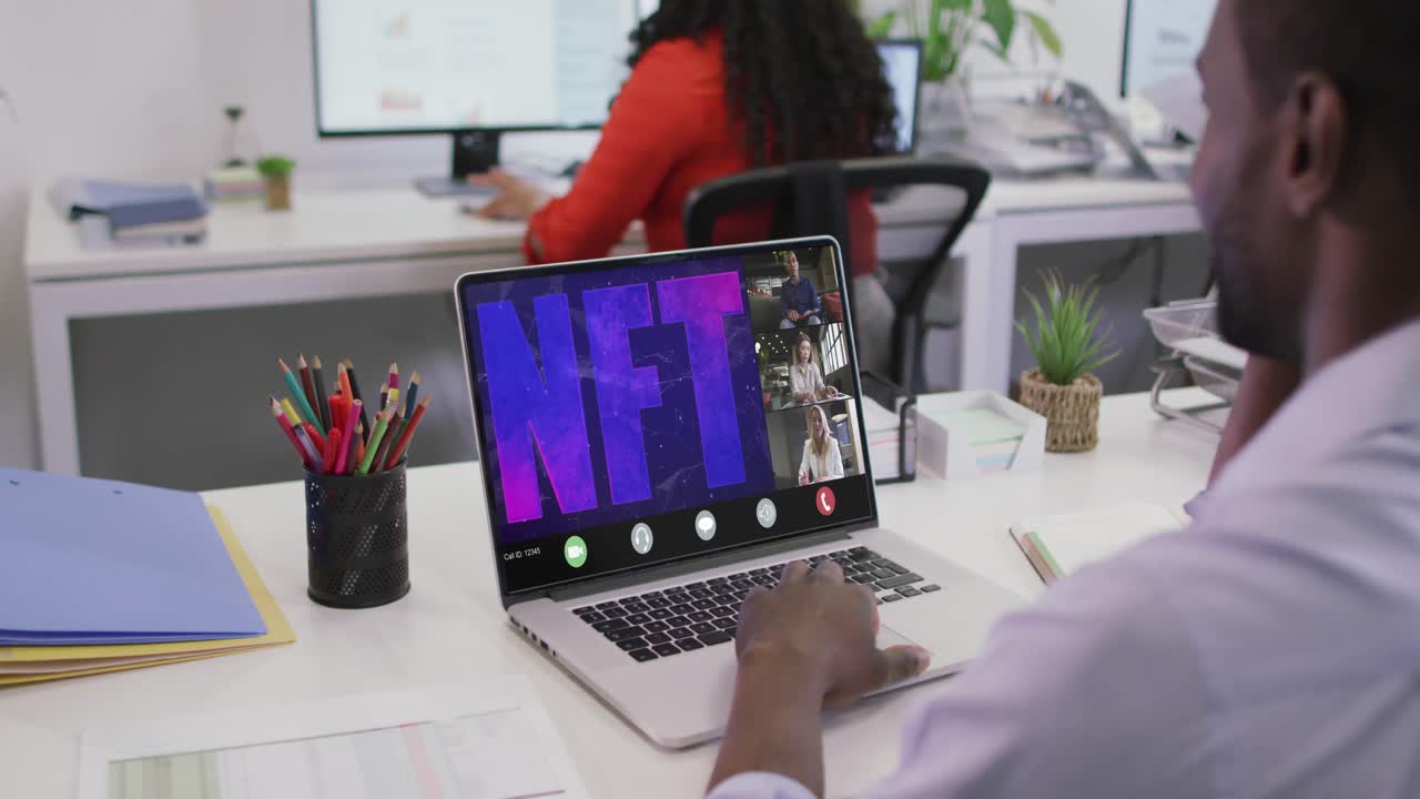 video de un hombre afroamericano haciendo una videollamada nft en una computadora portátil con varios compañeros de trabajo
