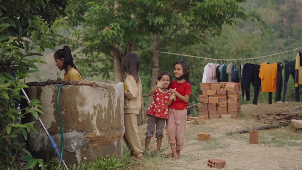 Children playing near a water well in a rural village
