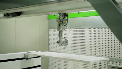industrial equipment for door production. automated machine is painting wooden board in white color. interior of modern manufacturing.