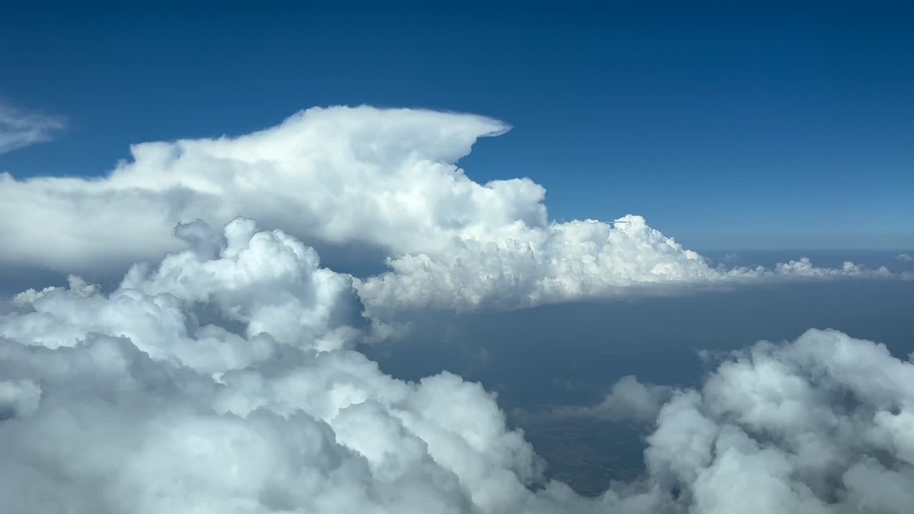 pov volando a través de un cielo azul con nubes de tormenta como lo ven los pilotos de un jet volando a nivel de crucero