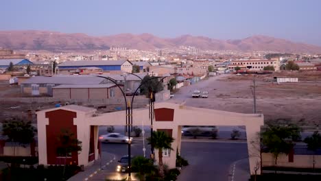 coches que viajan a lo largo de una carretera de la ciudad al atardecer en sulaymaniyah en kurdistán irak - tiro estático
