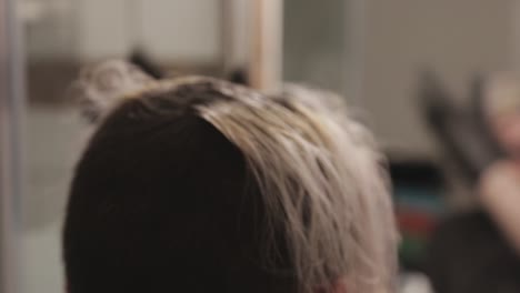 A-Young-Woman-Bleaching-Hair-While-Brushing-It-With-Her-Fingers---Close-Up-Shot