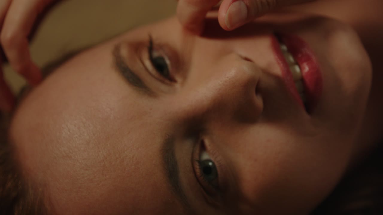 Beautiful macro of an attractive woman gently stroking her face in slow motion