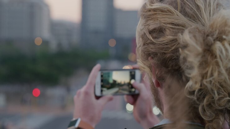 close up portrait young man tourist using smartphone taking photo of city sightseeing sharing travel experience on mobile phone camera slow motion