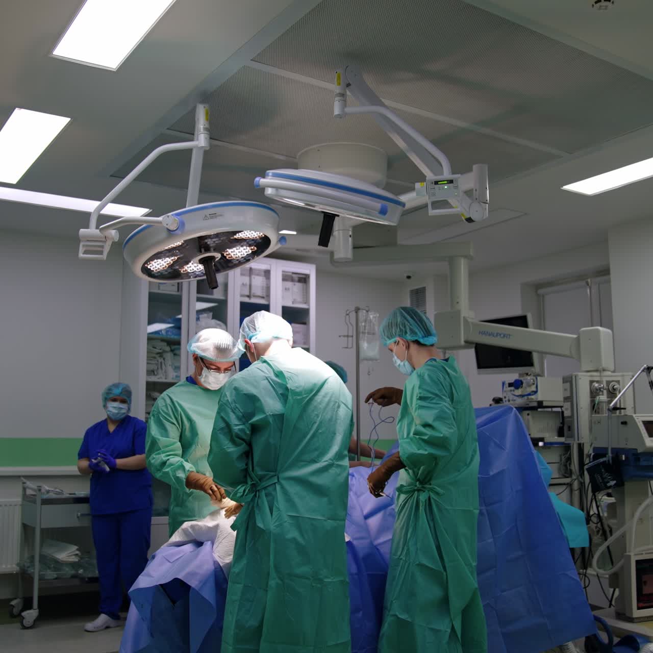 Equipe médica realizando uma operação em uma sala de cirurgia bem equipada. Médicos usam dispositivos e ferramentas elétricas.