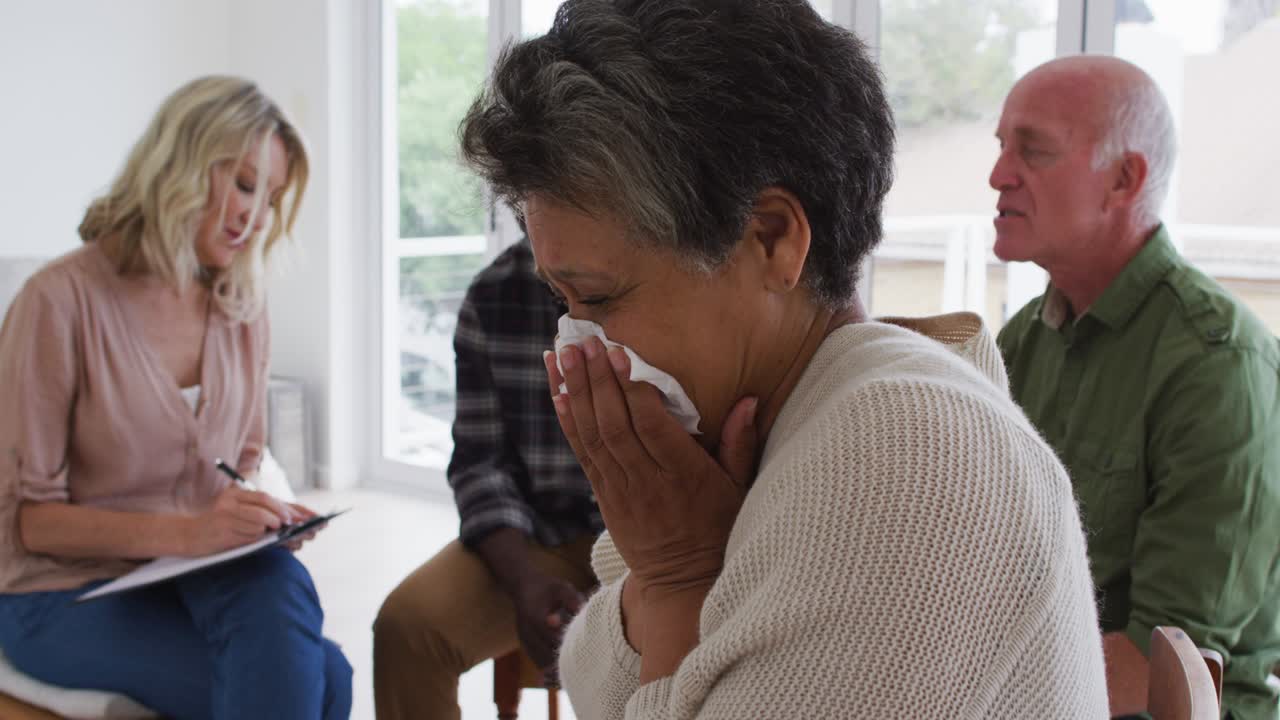 dos parejas de ancianos diversos sentados en círculo teniendo una conversación de terapia en casa