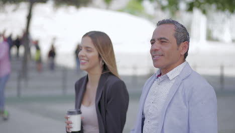 Happy-male-and-female-colleagues-walking-outdoor