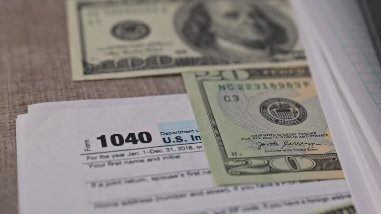 el formulario 1040 del irs con la declaración de impuestos sobre la renta individual de las facturas de dólares de estímulo económico