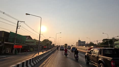 vehicles moving under a setting sun in urban area