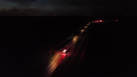 fire truck on dark highway in operation. car accident on suburb intersection. aerial wide shot. several helper in back.