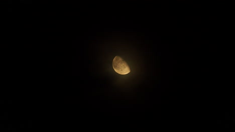 nubes pasando lentamente frente a una luna brillante en la noche