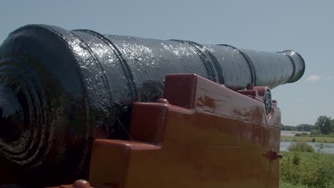 Panning-over-old-cannon-barrel-aimed-at-beautiful-dutch-landscape