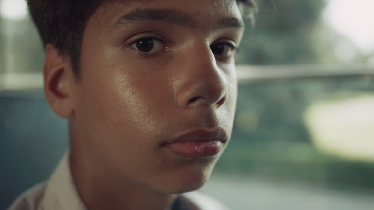Portrait Indian school boy looking camera in vehicle. Pupil posing at bus window