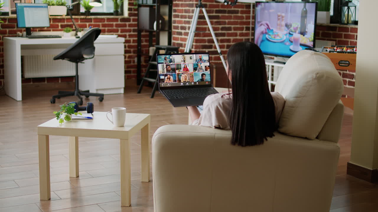 Woman on video call using laptop in living room