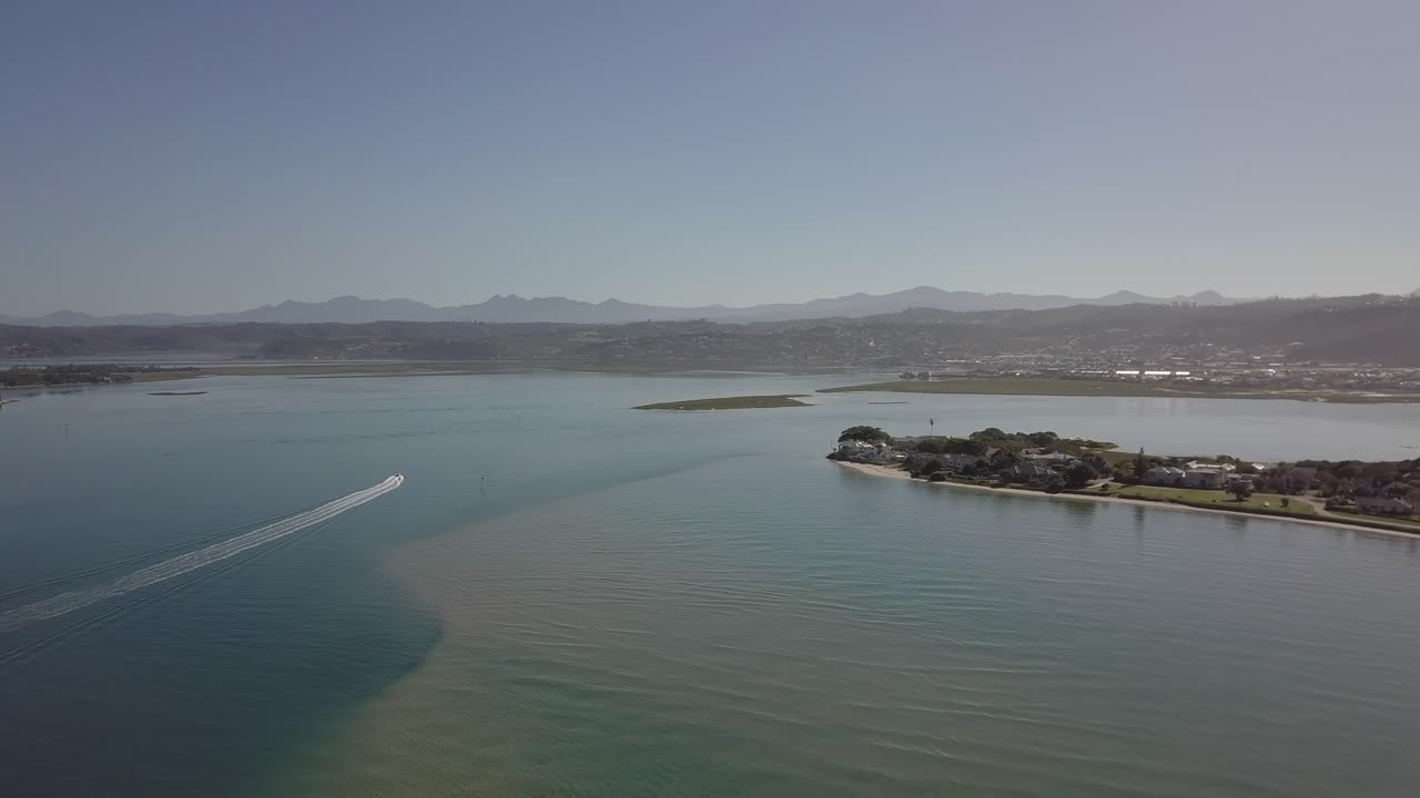 аэрофотосъемка: одинокий катер разворачивается в солнечной гавани лагуны книсна