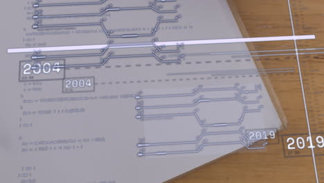Digital timeline animation over printed circuit diagrams on wooden table
