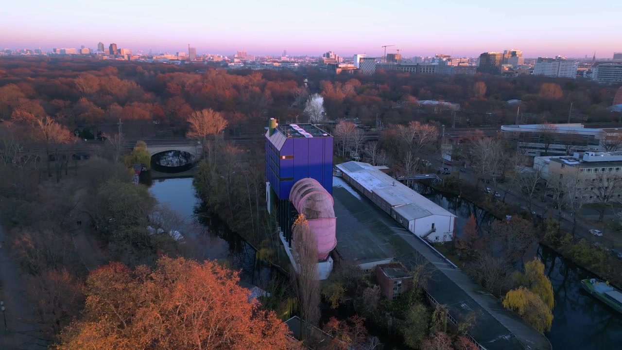 Husbåde med solpaneler fortøjet i en kanal, der spejler sig i det rolige vand ved skumringstid med Tiergarten Berlin-bygningen i baggrunden. Fantastisk drone-luftfoto med panoramaudsigt.