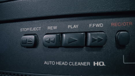 el botón de reproducción de vhs clásico es presionado por la mano de un hombre
