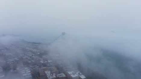 aerial ascent moving away from the george washington bridge on a very foggy morning in new york city