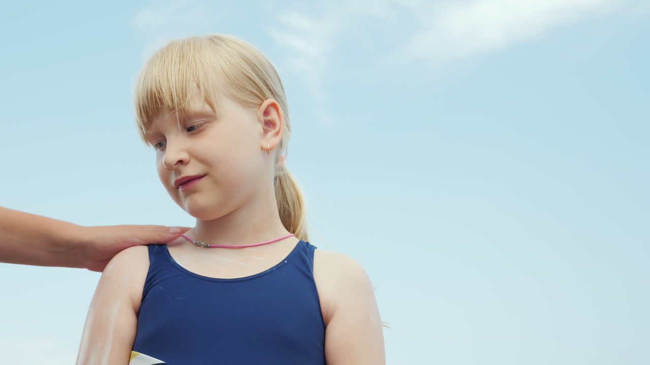 엄마는 휴가 4k 비디오에서 태양으로부터 딸의 자외선 차단제를 바르고 있습니다.