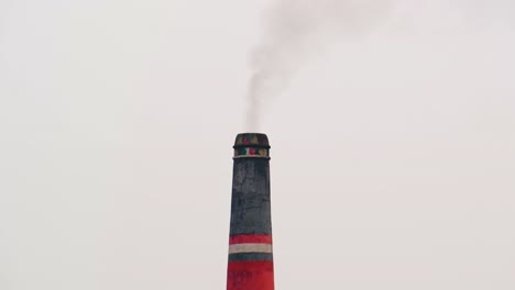 Vista-Media-De-La-Chimenea-De-La-Fábrica-De-Ladrillos-Que-Emite-Un-Pequeño-Humo-Negro