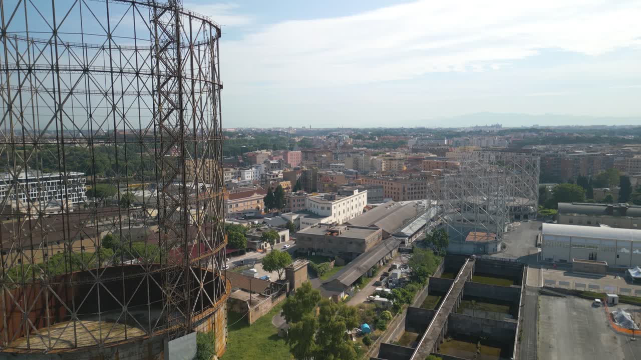 воздушный беспилотник вперед движущийся выстрел летает рядом со старым неохраняемым железным сооружением, газометром в районе остиенсе, рим, италия в дневное время